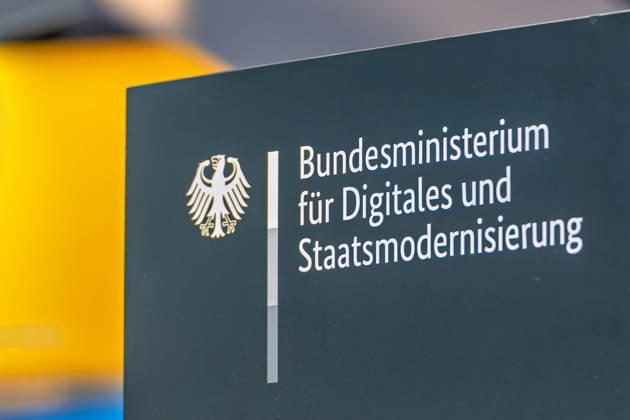 Berlin, 13.10.2026: Das Logo mit Bundesadler und dem Schriftzug Bundesministerium für Digitales und Staatsmodernisierung am Messestand des Ministeriums auf der Smart Country Convention. Das 2025 gegründete Ministerium unter Karsten Wildberger soll die Digitalisierung des Staates bündeln. Die Smart Country Convention (SCCON) ist die Kongressmesse für die Digitalisierung des öffentlichen Sektors und wird vom Digitalverband Bitkom gemeinsam mit der Messe Berlin veranstaltet. Vom 13. bis 15. Oktober 2026 treffen sich auf dem Berliner Messegelände Vertreter aus Bund, Ländern und Kommunen mit Unternehmen der Digitalwirtschaft, um über digitale Verwaltung, Smart City und digitale Souveränität zu diskutieren. Logo des Bundesdigitalm