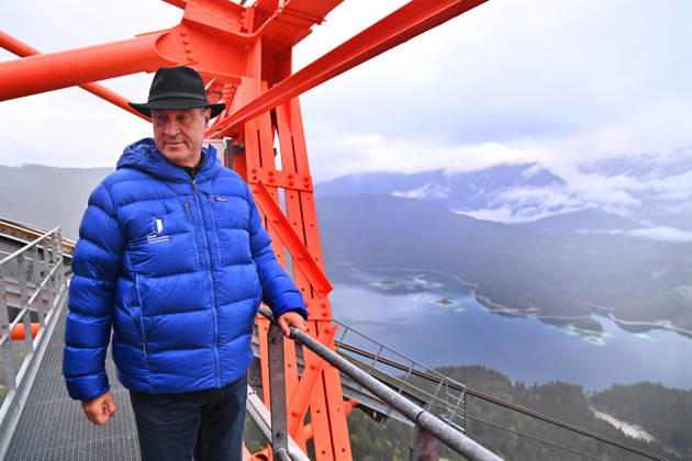 Markus SOEDER, Minister-President of Bavaria and CSU Chairman, steps out of the Zugspitzbahn gondola halfway up the mountain, stands on one of the cable car’s support towers at a dizzying height, and looks o