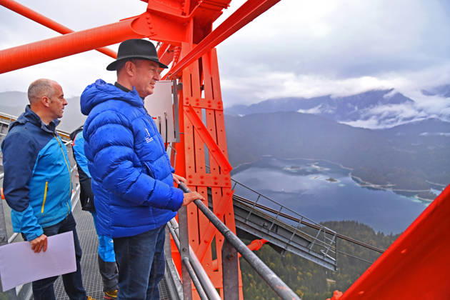 Markus SOEDER, Minister-President of Bavaria and CSU Chairman, steps out of the Zugspitzbahn gondola halfway up the mountain, stands on one of the cable car’s suppor