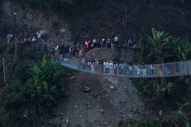 Nepal Bridge Restores Flood-Hit Access NUWAKOT, NEPAL, OCTOBER 14, 2026: Residents cross a newly built suspension bridge over the Trishuli River in Nuwakot, restoring access between communities affected by flash floods. Flooding destroyed bridges and damaged roads in the district, disrupting travel and access to essential services. NUWAKOT Nepal Copyright: x xShankarxBhujelx xJNAxPressx