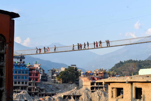 Aftermath of flash floods in Nepal NUWAKOT, NEPAL - OCTOBER 14 : People walk across a newly built suspension bridge over the Trishuli River, Nuwakot district, Nepal on October 14, 2026. Road and pedestrian connectivity has been restored with the construction of a new suspension bridge over the Trishuli River, allowing local residents to cross the river after the devastating floods damaged bridges and other infrastructure in the area. Sunil Pradhan Anadolu Nuwakot Nepal. Editorial use only. Please get in touch for any other usage.  Copyright: x2026xAnadoluxSunilxPradhanx