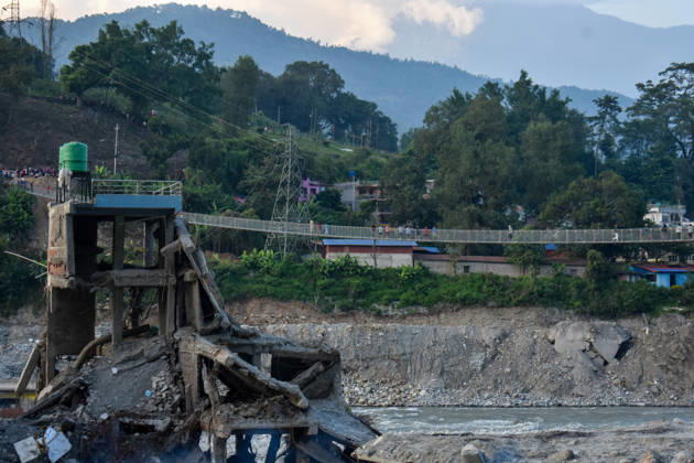 Aftermath of flash floods in Nepal NUWAKOT, NEPAL - OCTOBER 14 : People walk across a newly built suspension bridge over the Trishuli River, Nuwakot district, Nepal on October 14, 2026. Road and pedestrian connectivity has been restored with the construction of a new suspension bridge over the Trishuli River, allowing local residents to cross the river after the devastating floods damaged bridges and other infrastructure in the area. Sunil Pradhan Anadolu Nuwakot Nepal. Editorial use only. Please get in touch for any other usage.  Copyright: x2026xAnadoluxSunilxPradhanx