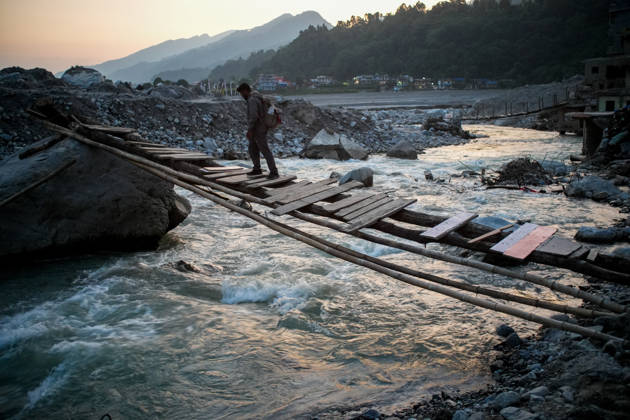 Aftermath of flash floods in Nepal RASUWA, NEPAL - OCTOBER 14 : A man crosses a temporary bridge over a river in Rasuwa district, Nepal on October 14, 2026. Road and pedestrian connectivity has been restored with the construction of a new suspension bridge over the Trishuli River, allowing local residents to cross the river after the devastating floods damaged bridges and other infrastructure in the area. Sunil Pradhan Anadolu Rasuwa Nepal. Editorial use only. Please get in touch for any other usage.  Copyright: x2026xAnadoluxSunilxPradhanx