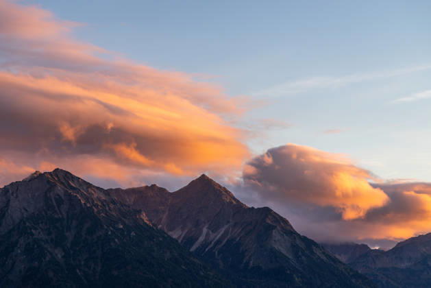 Autumn Evening in the Allgäu: The clouds in the sky glow in the evening sun above the peaks of the Allgäu Alps, Bad Hindelang, Bavaria, Germany