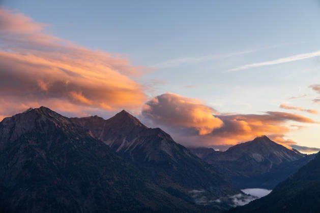 Autumn Evening in the Allgäu: The clouds in the sky glow in the evening sun above the peaks of the Allgäu Alps, Bad Hindelang, Bavaria, Germany