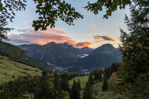 Autumn Evening in the Allgäu: The clouds in the sky glow in the evening sun above the peaks of the Allgäu Alps, Bad Hindelang, Bavaria, Germany