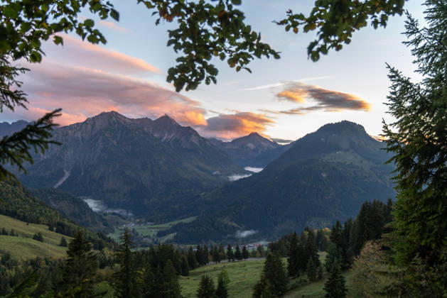 Autumn Evening in the Allgäu: The clouds in the sky glow in the evening sun above the peaks of the Allgäu Alps, Bad Hindelang, Bavaria, Germany