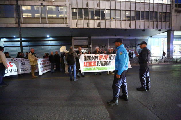 October 15, 2026, Athens, Attica, GREECE: Police officers stand near demonstrators carrying banners calling for higher wages and pensions during an evening protest march. Athens GREECE - ZUMAx103 20261015_zip_x103_008 Copyright: xHarrisxXanthopoulosx