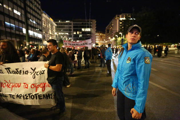October 15, 2026, Athens, Attica, GREECE: A police officer stands beside demonstrators holding banners during an evening march calling for higher wages and pensions. Athens GREECE - ZUMAx103 20261015_zip_x103_018 Copyright: xHarrisxXanthopoulosx