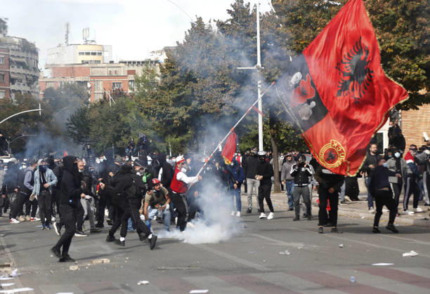 Protesters Clash with Police During a Demonstration in Tirana, Albania. Protesters hold an Albanian flag as they throw stones to riot police during an anti-government demonstration in central Tirana on October 15, 2026, as protests continued for a third consecutive day over university conditions and demands for the resignation of Albanian Prime Minister Edi Rama. The latest rally follows two nights of violence in the capital, during which protesters and riot police clashed, police used water cannons and tear gas, and demonstrators damaged government offices and shops and set fire to several buildings. Light Studio Agency Malton Dibra Tirana Albania Copyright: xLightxStudioxAgencyx xMaltonxDibrax