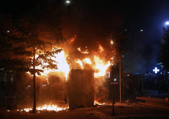 Protesters Clash with Police During a Demonstration in Tirana, Albania. Protesters walk in front of a burning kiosk during an anti-government demonstration in central Tirana on October 15, 2026, as protests continued for a third consecutive day over university conditions and demands for the resignation of Albanian Prime Minister Edi Rama. The latest rally follows two nights of violence in the capital, during which protesters and riot police clashed, police used water cannons and tear gas, and demonstrators damaged government offices and shops and set fire to several buildings. Light Studio Agency Malton Dibra Tirana Albania Copyright: xLightxStudioxAgencyx xMaltonxDibrax