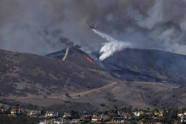 October16, 2026, San Juan Capistrano, California, USA: Fire crews are aggressively battling a wind-driven brush fire that burned several homes and threatened thousands of others in the area of San Juan Capistrano and San Clemente Friday, prompting evacuation orders. The Norte Fire exploded to 465 acres and remains 0 percent contained as of 4 p.m. O.C. Fire Authority officials said the Norte Fire started around 11:30 a.m. near Portico Del Norte and Eminencia Del Norte in San Clemente, east of Interstate 5. Fueled by strong Santa Ana winds, the wildfire then blew into neighboring San Juan Capistrano. San Juan Capistrano USA - ZUMAr19_ 20261016_new_r19_167 Copyright: xRuaridhxStewartx