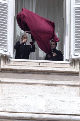 October 18, 2026, Vatican City, Vatican: Pope Leo XIV s personal secretaries, Father Marco Billeri and Monsignor Edgard Ivan Rimaycuna Inga, hang a tapestry bearing the pontiff s coat of arms from a window of Pope s study overlooking St. Peter s Square, before the traditional Angelus prayer at the Vatican.Pope Leo XIV during Sunday Angelus Prayer in Vatican Vatican City Vatican  - ZUMAs197 20261018_aaa_s197_007 Copyright: xMariaxGraziaxPicciarellax