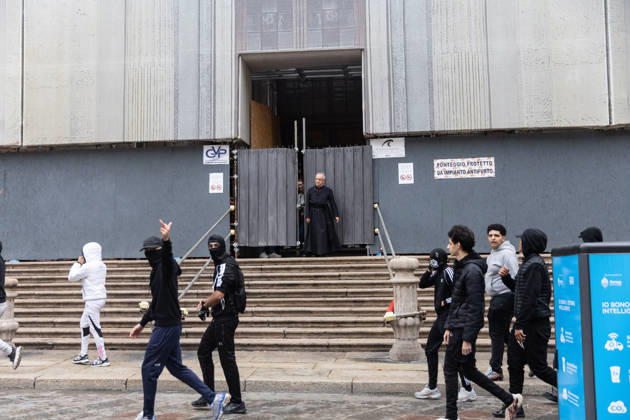IPA89867615 - Milan, October 18, 2026: More Clashes and Looting in Downtown Milan the Day After the Protest; pictured: a priest closes the church to protesters seeking shelter Copyright: xFrancescoxEnriquezx xFrancescoxEnriquezx IPA89867615