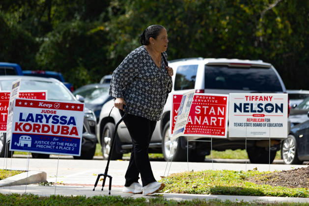 A woman walks past campaign advertising during the early voting period at the George Bush center in Houston, Texas, United States, 19 October 2026. Early voting begins in several key states in the United States !ACHTUNG: NUR REDAKTIONELLE NUTZUNG!  Copyright: xCarlosxRamírezx AME7595 20261019-55021730465_1