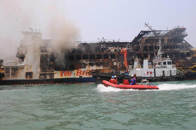 Efforts are underway to extinguish a fire that broke out on a passenger ferry in Indonesia s Cilegon PELABUHAN MERAK, CILEGON, INDONESIA - OCTOBER 21: Fireboats take turns spraying water onto the passenger ferry KMP Batumandi to cool down the vessel after it caught fire while preparing to dock off Merak Port in Cilegon, Banten, Indonesia on Wednesday, October 21, 2026. The vessel caught fire on Tuesday, October 20, and rescue operations remain underway as the ship continues to emit smoke. Water is continuously sprayed to cool the vehicle deck containing numerous cars, motorcycles, buses, and trucks, while authorities confirm no fatalities have been reported. Dasril Roszandi Anadolu Pelabuhan Merak Indonesia. Editorial use only. Please get Copyright: x2026xAnadoluxDasrilxRoszandix