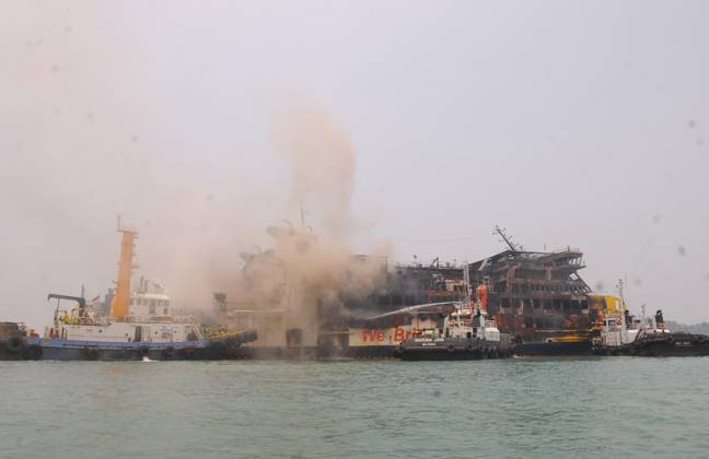 Efforts are underway to extinguish a fire that broke out on a passenger ferry in Indonesia s Cilegon PELABUHAN MERAK, CILEGON, INDONESIA - OCTOBER 21: Fireboats take turns spraying water onto the passenger ferry KMP Batumandi to cool down the vessel after it caught fire while preparing to dock off Merak Port in Cilegon, Banten, Indonesia on Wednesday, October 21, 2026. The vessel caught fire on Tuesday, October 20, and rescue operations remain underway as the ship continues to emit smoke. Water is continuously sprayed to cool the vehicle deck containing numerous cars, motorcycles, buses, and trucks, while authorities confirm no fatalities have been reported. Dasril Roszandi Anadolu Pelabuhan Merak Indonesia. Editorial use only. Please get Copyright: x2026xAnadoluxDasrilxRoszandix