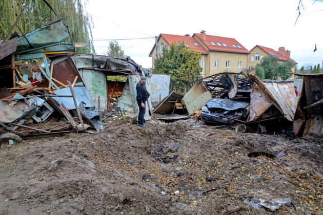 A man looks at a crater in the ground near destroyed garages left by a Russian drone attack, Petropavlivska Borshchahivka, Kyiv region, Ukraine, October 21, 2026. (Photo by Volodymyr Tarasov Ukrinform) Consequences of Russian drone attack in Kyiv region  Copyright: xVolodymyrxTarasovx