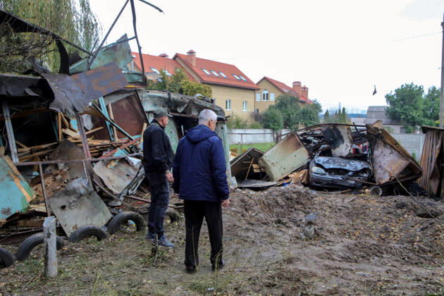 Two men face a burnt-out car in a garage destroyed by a Russian drone attack, Petropavlivska Borshchahivka, Kyiv region, Ukraine, October 21, 2026. (Photo by Volodymyr Tarasov Ukrinform) Consequences of Russian drone attack in Kyiv region  Copyright: xVolodymyrxTarasovx
