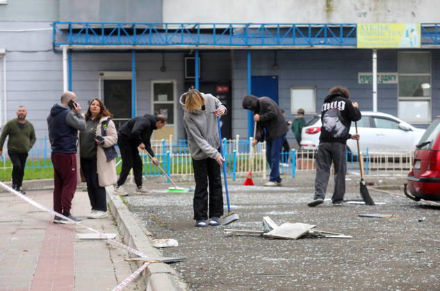 People remove debris and glass shards outside an apartment block in the Sviatoshynskyi district damaged by a Russian drone strike, Kyiv, Ukraine, October 21, 2026. The drone hit the building’s 20th floor, sparking a fire. Two people were killed in the attack. (Photo by Volodymyr Tarasov Ukrinform) Russian drone hits 24-storey apartment block in Kyiv  Copyright: xVolodymyrxTarasovx