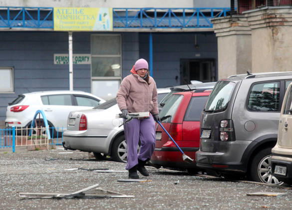 A woman removes glass shards outside an apartment block in the Sviatoshynskyi district damaged by a Russian drone strike, Kyiv, Ukraine, October 21, 2026. The drone hit the building’s 20th floor, sparking a fire. Two people were killed in the attack. (Photo by Volodymyr Tarasov Ukrinform) Russian drone hits 24-storey apartment block in Kyiv  Copyright: xVolodymyrxTarasovx