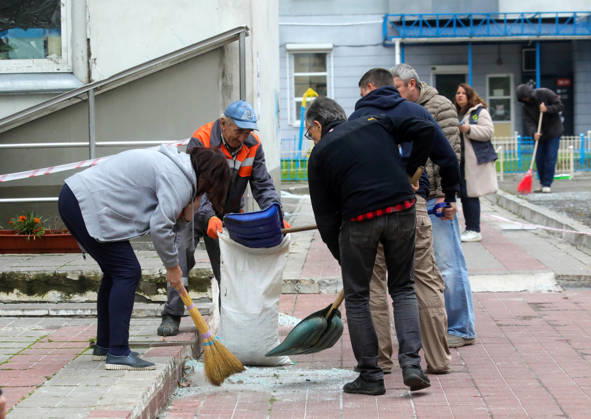 People remove debris and glass shards outside an apartment block in the Sviatoshynskyi district damaged by a Russian drone strike, Kyiv, Ukraine, October 21, 2026. The drone hit the building’s 20th floor, sparking a fire. Two people were killed in the attack. (Photo by Volodymyr Tarasov Ukrinform) Russian drone hits 24-storey apartment block in Kyiv  Copyright: xVolodymyrxTarasovx