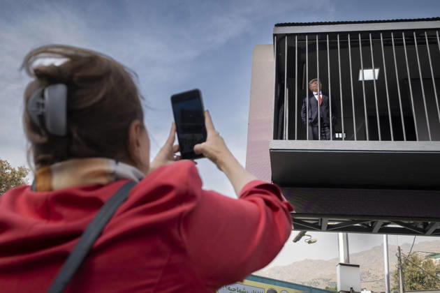 Anti-U.S. President Trump Performance On Billboard Reactions An Iranian woman films a masked man (not pictured) performing as U.S. President Donald Trump inside a symbolic cell mounted on a billboard in northern Tehran, Iran, on October 22, 2026, amid escalating tensions between Iran and the United States. Tehran Tehran Iran  Copyright: xMortezaxNikoubazlx originalFilename: nikoubazl-antiuspr261022_npqI7.jpg