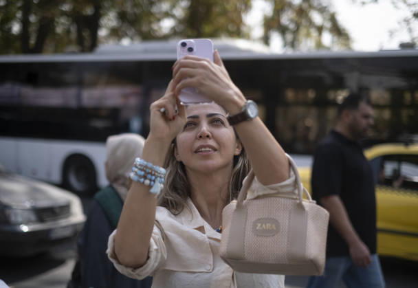 Anti-U.S. President Trump Performance On Billboard Reactions An Iranian woman films a masked man (not pictured) performing as U.S. President Donald Trump inside a symbolic cell mounted on a billboard in northern Tehran, Iran, on October 22, 2026, amid escalating tensions between Iran and the United States. Tehran Tehran Iran  Copyright: xMortezaxNikoubazlx originalFilename: nikoubazl-antiuspr261022_npypF.jpg