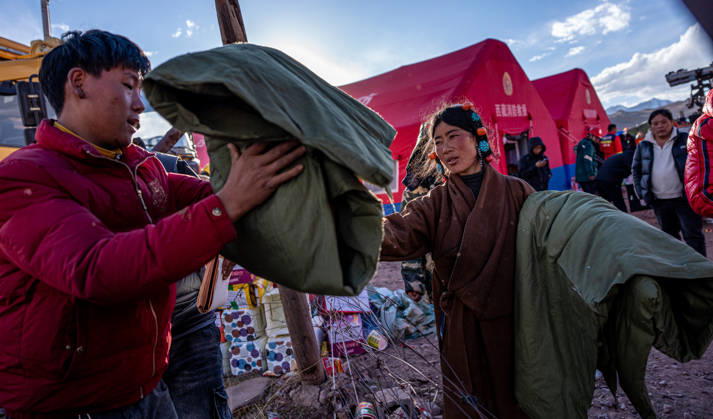 (261023) -- NAGQU, Oct. 23, 2026 -- Villagers receive quilts at a temporary resettlement site of an earthquake-hit village in Maru Township of Baqen County, Nagqu City, southwest China s Xizang Autonomous Region, Oct. 23, 2026. China has allocated 50 million yuan (about 7.5 million U.S. dollars) in emergency disaster relief funds and earmarked another 30 million yuan for recovery efforts following a 7.0-magnitude earthquake in southwest China s Xizang Autonomous Region. The earthquake struck Baqen County of the city of Nagqu at 10:33 p.m. on Thursday, leaving 16 people dead and 54 injured. ) (SpotNews) CHINA-XIZANG-NAGQU-EARTHQUAKE-RESETTLEMENT (CN) TenzinxNyida 