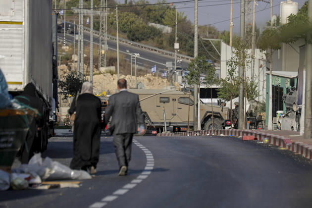 Hebron West Bank Shooting Attack Civilians walk along a road toward Israeli military vehicles at the entrance to Farsh al-Hawa near Hebron, in the occupied West Bank on October 23, 2026. Journalists were targeted and the area was declared a closed military zone following a Palestinian shooting attack targeting an Israeli military checkpoint at the entrance to Farsh al-Hawa in Hebron. Hebron West Bank Palestinian Territories Copyright: xMosabxShawerx
