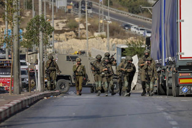 Hebron West Bank Shooting Attack Israeli military forces walk down the road at the entrance to Farsh al-Hawa near Hebron, in the occupied West Bank on October 23, 2026. Journalists were targeted and the area was declared a closed military zone following a Palestinian shooting attack targeting an Israeli military checkpoint at the entrance to Farsh al-Hawa in Hebron. Hebron West Bank Palestinian Territories Copyright: xMosabxShawerx