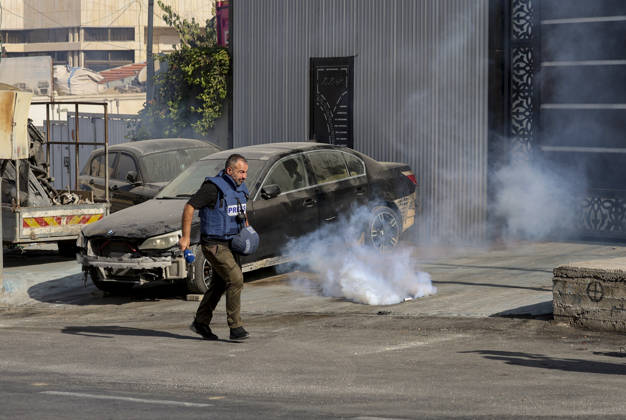 Hebron West Bank Shooting Attack A journalist runs away as tear gas disperses near Farsh al-Hawa in Hebron, in the occupied West Bank on October 23, 2026. Journalists were targeted and the area was declared a closed military zone following a Palestinian shooting attack targeting an Israeli military checkpoint at the entrance to Farsh al-Hawa in Hebron. Hebron West Bank Palestinian Territories Copyright: xMosabxShawerx