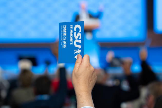 Munich, Bavaria, Germany October 23, 2026: The 2026 convention of the CSU (Christian Social Union) at the Munich Trade Fair Center. A hand holds a voting card aloft