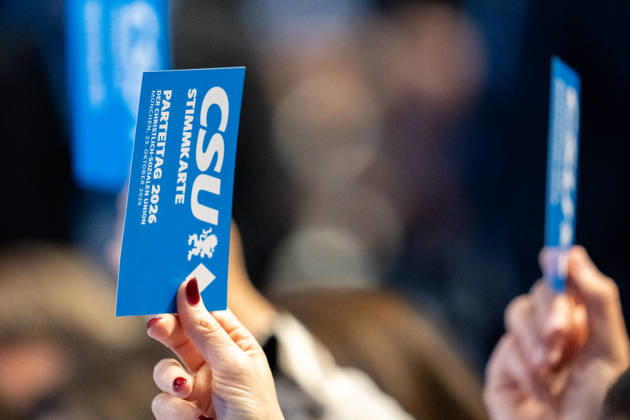 Munich, Bavaria, Germany October 23, 2026: The 2026 convention of the CSU (Christian Social Union) at the Munich Trade Fair Center. A hand holds a voting card aloft