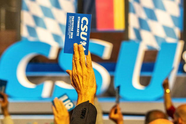 Delegates use their voting cards to approve one of the motions; motion deliberations on Friday evening; CSU Party Convention; Messe München; October 23, 2026, Germany; Munich, October 23, 2026, delegates use their voting cards to approve one of the motions, CSU logo in the background, motion deliberations on Friday evening, CSU Party Convention on October