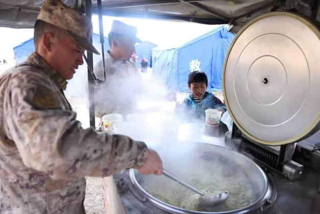 (261024) -- NAGQU, Oct. 24, 2026 -- A soldier from a local subcommand of the Western Theater Command of the Chinese People s Liberation Army cooks meal for local residents at a temporary resettlement site of a quake-hit village in Maru Township of Baqen County, Nagqu City, southwest China s Xizang Autonomous Region, Oct. 23, 2026. Sixteen people have been killed and 76 others are injured following a 7.0-magnitude earthquake that struck Baqen County of the city of Nagqu in southwest China s Xizang Autonomous Region at 10:33 p.m. on Thursday, local authorities said. The Western Theater Command of the Chinese People s Liberation Army has coordinated ground and air forces to assess the damage and carry out search-and-rescue operations. Mor 