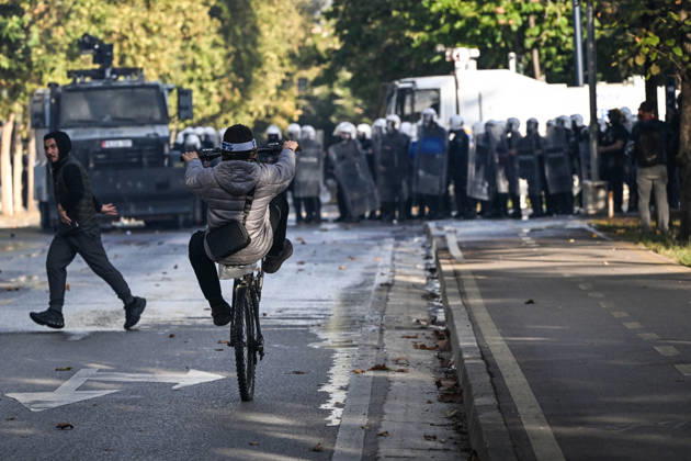 Mass Anti-Government National Protest in Tirana TIRANA, ALBANIA - OCTOBER 24: A young cyclist performs a wheelie on a wet street while moving away from an advancing line of riot police shields and armored vehicles on October 24, 2026, in Tirana, Albania. Unrest and physical confrontations erupt in Tirana city center as demonstrators and riot police clash during a massive nationwide protest, turning the capital s main avenue into a major flashpoint as chaotic skirmishes broke out between security forces and factions of the crowd. Artur Widak Anadolu Tirana Albania. Editorial use only. Please get in touch for any other usage.  Copyright: x2026xAnadoluxArturxWidakx
