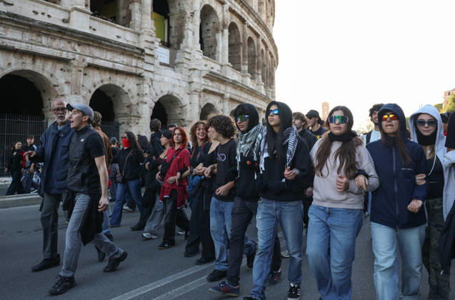(261024) -- ROME, Oct. 24, 2026 -- Demonstrators march past the Colosseum during an anti-war march in Rome, Italy, Oct. 24, 2026. Protests over rising living costs, military expansion and increased arms spending swept across several Italian cities on Saturday, with clashes between demonstrators and police reported in multiple locations. In Rome, demonstrators set off from Piazza della Repubblica, according to the ANSA news agency. Clashes erupted between protesters and police in the city center later in the evening, prompting police to use water cannons and tear gas in an attempt to disperse the crowds. ) ITALY-ROME-PROTESTS WangxKaiyan 