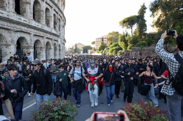 (261024) -- ROME, Oct. 24, 2026 -- Demonstrators march past the Colosseum during an anti-war march in Rome, Italy, Oct. 24, 2026. Protests over rising living costs, military expansion and increased arms spending swept across several Italian cities on Saturday, with clashes between demonstrators and police reported in multiple locations. In Rome, demonstrators set off from Piazza della Repubblica, according to the ANSA news agency. Clashes erupted between protesters and police in the city center later in the evening, prompting police to use water cannons and tear gas in an attempt to disperse the crowds. ) ITALY-ROME-PROTESTS WangxKaiyan 