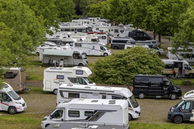 Parkplatz Reisemobil?Park?Treviris mit zahlreichen weißen und grauen Wohnmobilen, geordnet auf gepflasterten Stellflächen zwischen grünen Bäumen und Sträuchern, einige Fahrzeuge mit ausgefahrenen Markisen und Fahrrädern, Trier, Rheinland-Pfalz, Deutschland Car park motorhome Park Treviris with numerous white and grey camper vans, arranged on paved parking spaces between green trees and bushes, some vehicles with extended awnings and bicycles, Trier, Rhineland-Palatinate, Germany Copyright: imageBROKER StanislavxBelicka ibxbsb19476440.jpg