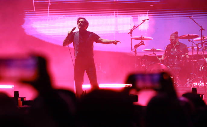 October 24, 2026, Tijuana, Baja California, Mexico: October 24, 2026, Tijuana, Baja California, Mexico: Luis Humberto Navejas of Enjambre performs on stage under intense magenta lighting as audience members capture the show on mobile phones during the Tecate Peninsula 2026 music festival in Tijuana. Tijuana Mexico - ZUMAm311 20261024_zip_m311_019 Copyright: xAlbertoxMartinezx
