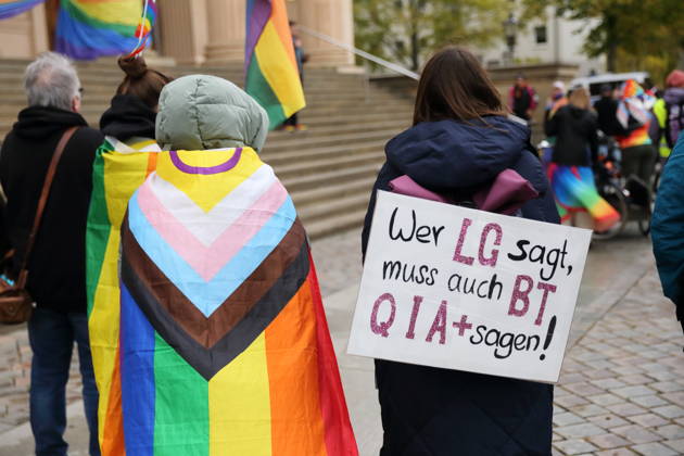 Protesters stand with a rainbow flag and a sign reading If you say LG, you must also say BTQIA at the Alter Markt during Bike Pride in Potsdam, October 24, 2026. Bike Pride Potsdam