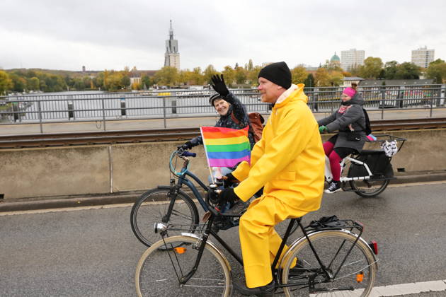 Protesters ride across the Humboldt Bridge on Nuthestraße, heading out of town, carrying a rainbow flag during Bike Pride in Potsdam, October 24, 2026. Bike Pride Potsdam