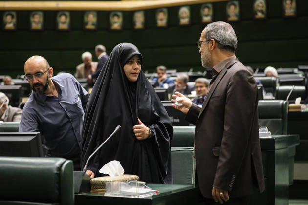 October 25, 2026, Tehran, Iran: A woman in a black chador talks with a gray-haired man as another member stands nearby in the chamber at the Islamic Consultative Assembly in Tehran, Iran, on October 25, 2026. The Iranian parliament held a hybrid open sitting, with some lawmakers attending in the Tehran chamber and others participating remotely, according to parliamentary reports. Tehran Iran - ZUMAi98_ 20261025_zih_i98_082 Copyright: xIcanax