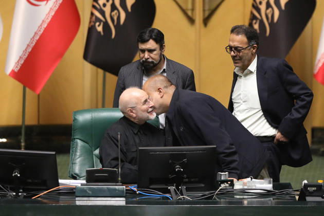 October 25, 2026, Tehran, Iran: Mohammad Bagher Ghalibaf talks with a man leaning toward his chair while two other officials stand behind the presiding desk at the Islamic Consultative Assembly in Tehran, Iran, on October 25, 2026. Parliamentary reports said more than two-thirds of lawmakers joined the October 25 open sitting of the Islamic Consultative Assembly, attending either in person or remotely. Tehran Iran - ZUMAi98_ 20261025_zih_i98_108 Copyright: xIcanax