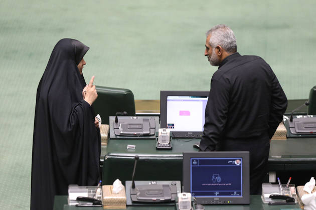 October 25, 2026, Tehran, Iran: A woman in a black chador raises her index finger while speaking to a gray-haired man beside parliament seating at the Islamic Consultative Assembly in Tehran, Iran, on October 25, 2026. Parliamentary reports said more than two-thirds of lawmakers joined the October 25 open sitting of the Islamic Consultative Assembly, attending either in person or remotely. Tehran Iran - ZUMAi98_ 20261025_zih_i98_125 Copyright: xIcanax