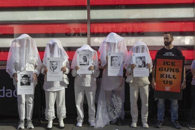 October 25, 2026, New York, New York, USA: People dressed in white shrouds are Human Beings, memorializing people killed by gun violence from Federal immigration agents by holding signs with the images and names of Ruben Ray Martinez Alex Jeffrey Pretti Renee Nicole Good Silverio Villegas Gonzalez Jonah Neal. Demonstrators with the anti-gun violence organization Gays Against Guns protest under the Times Square US Army Recruiting Station LED American flag to denounce U.S. Immigration and Customs Enforcement (ICE,) President Trump s immigrant detention and mass deportation policies. Protesters hold signs that read ICE GUNS KILL US. New York USA  - ZUMAr174 20261025_znp_r174_017 Copyright: xGinaxMxRandazzox
