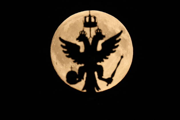 RUSSIA, MOSCOW - OCTOBER 25, 2026: The Russian coat of arms atop a building is silhouetted against the full moon shining over the city Moscow Russia  - ZUMAt113 20261025_zaa_t113_334 Copyright: xSergeixSavostyanovx