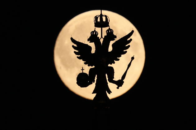 RUSSIA, MOSCOW - OCTOBER 25, 2026: The Russian coat of arms atop a building is silhouetted against the full moon shining over the city Moscow Russia  - ZUMAt113 20261025_zaa_t113_325 Copyright: xSergeixSavostyanovx