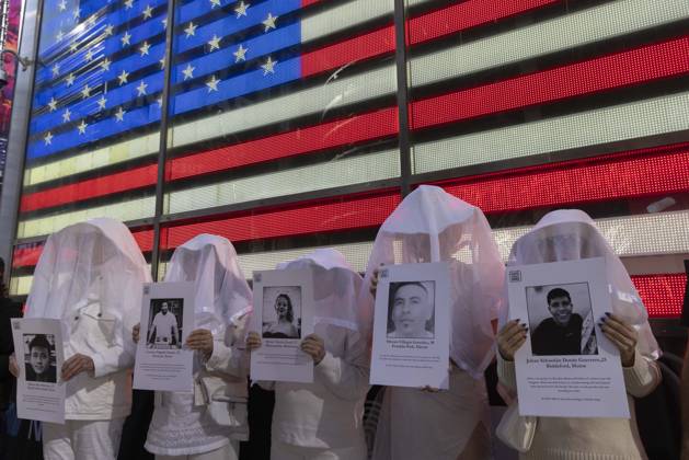 October 25, 2026, New York, New York, USA: People dressed in white shrouds are Human Beings, memorializing people killed by gun violence from Federal immigration agents by holding signs with the images and names of Ruben Ray Martinez Lorenzo Salgado Araujo Renee Nicole Good Silverio Villegas Gonzalez Johan Sebastian Duran Guerrero. Demonstrators with the anti-gun violence organization Gays Against Guns protest under the Times Square US Army Recruiting Station LED American flag to denounce U.S. Immigration and Customs Enforcement (ICE,) President Trump s immigrant detention and mass deportation policies. New York USA  - ZUMAr174 20261025_znp_r174_008 Copyright: xGinaxMxRandazzox